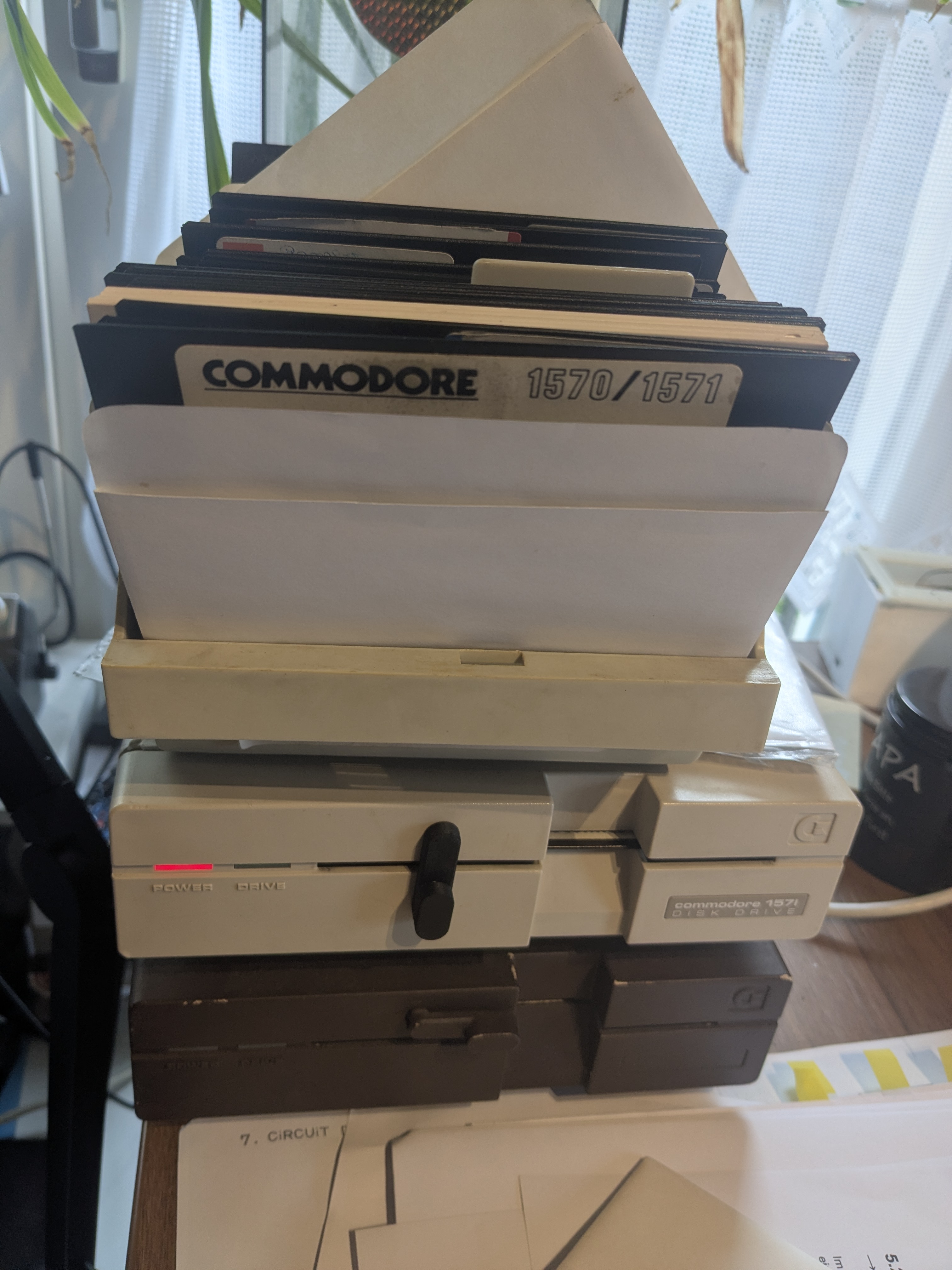 Stapel aus Commodore 1571 Diskettenlaufwerken mit 5,25-Zoll-Disketten und dem 1570/1571 Handbuch