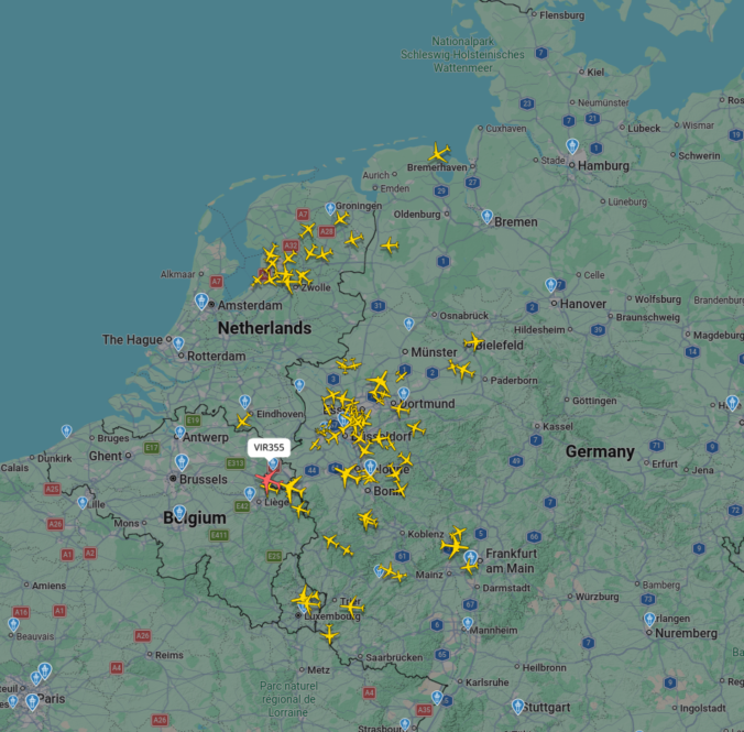 Kartenansicht von Mitteleuropa mit zahlreichen gelben Flugzeugsymbolen, die aktuellen Flugverkehr anzeigen. Hohe Dichte über Nordrhein-Westfalen, Benelux und den Niederlanden; einzelne Flugzeuge auch über Norddeutschland und Südwestdeutschland verteilt.