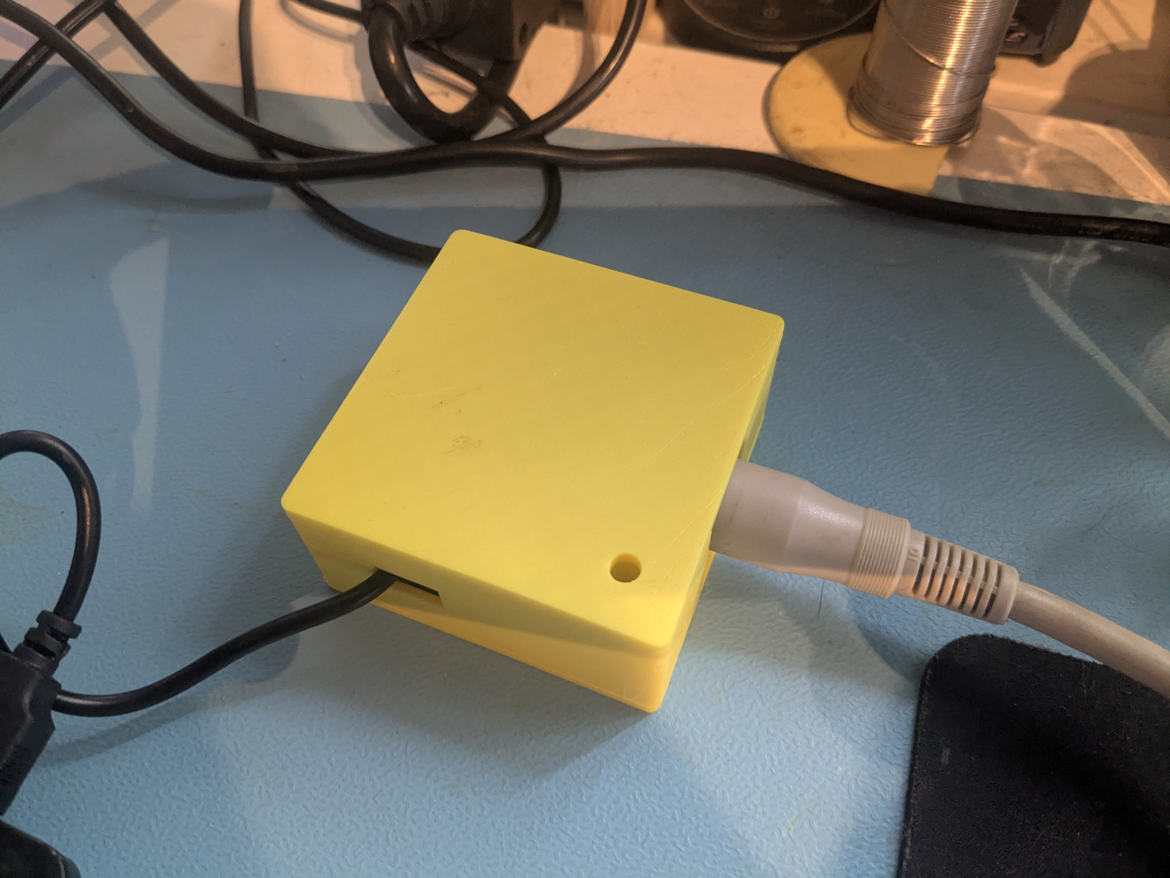 xum1541 USB-Adapter im gelben 3D-gedruckten Gehäuse mit USB- und IEC-Kabel angeschlossen