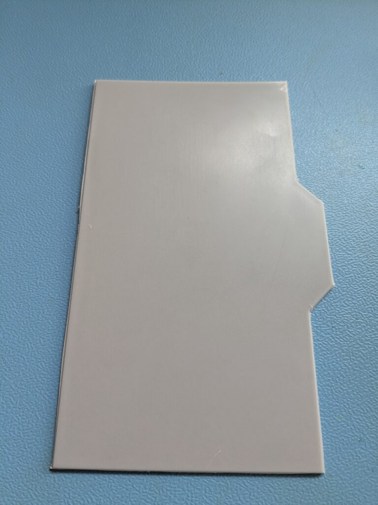 Aus der Trocknerwand herausgeschnittenes Kunststoffstück an der vorperforierten Stelle der Service-Öffnung