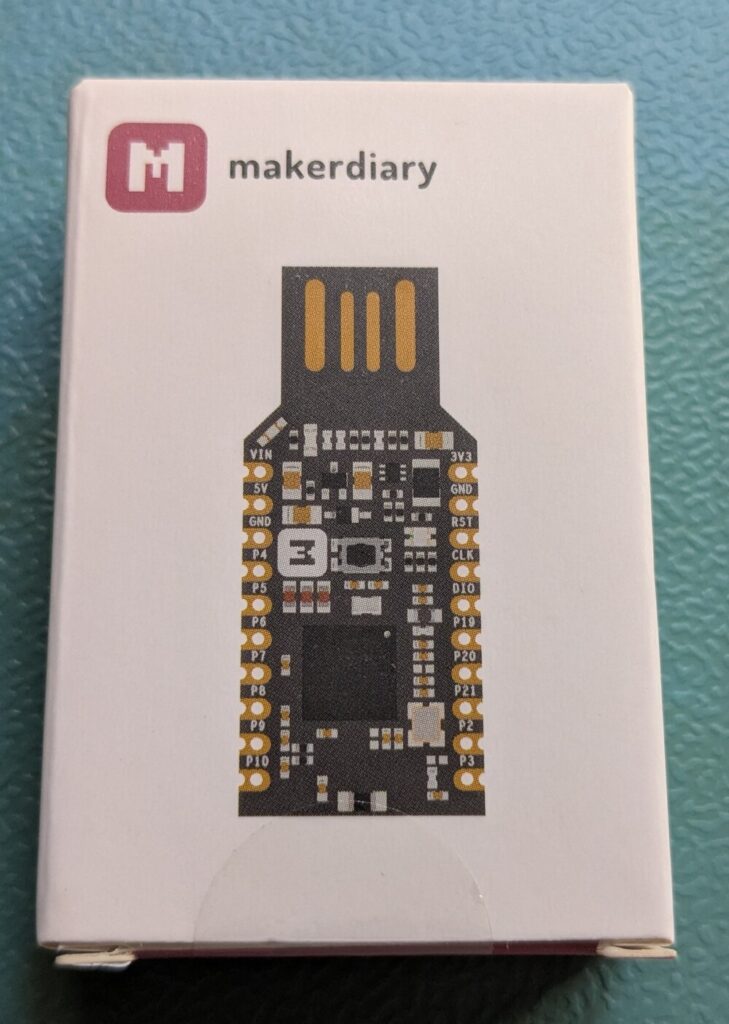 Verpackung des makerdiary nRF52840-MDK USB Dongle mit aufgedrucktem Board-Layout und Pinbelegung.